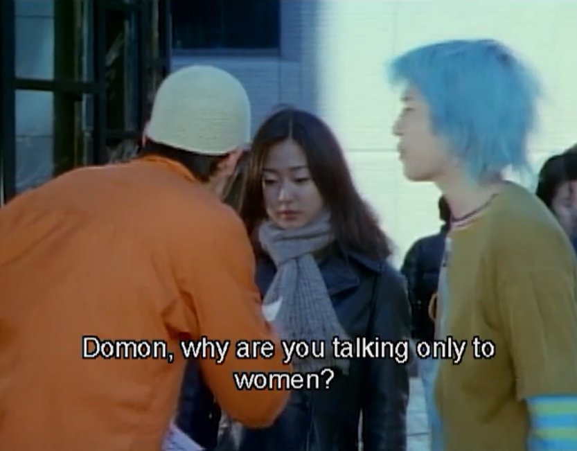 Shion, hair bluer again, talking to Domon, a man in a knit hat and orange jacket.  Shion: Domon, why are you talking only to women?