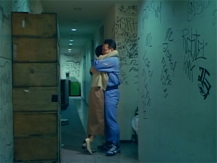 Two people hugging in a graffiti covered corridor.  FLAPP MC LORD POUSHKEEPSIE NY is among the graffiti.