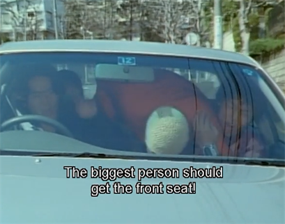 Timerangers in a car, driven by Ayase, and Domon trying to climb into the front from the back.  Domon: The biggest person should get the front seat!