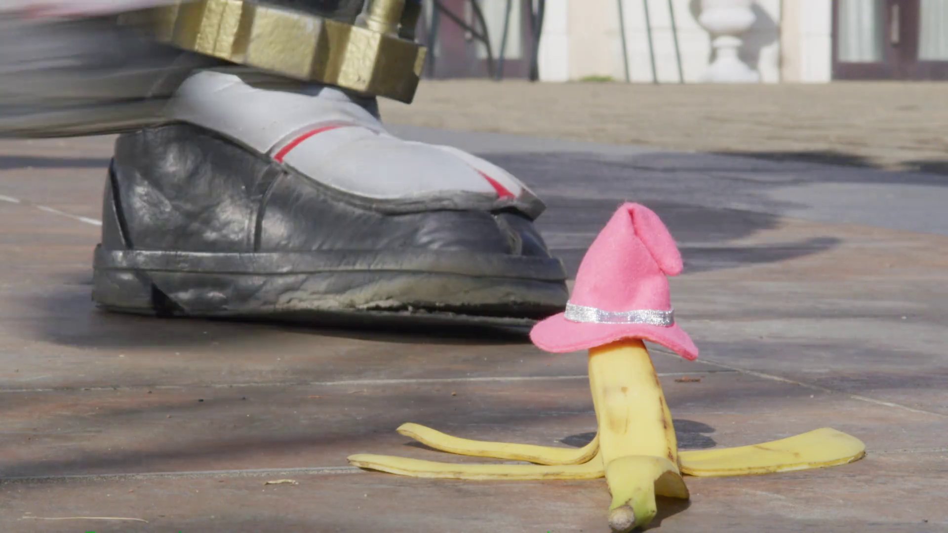 A banana peel on the floor, wearing a tiny pink witch hat.