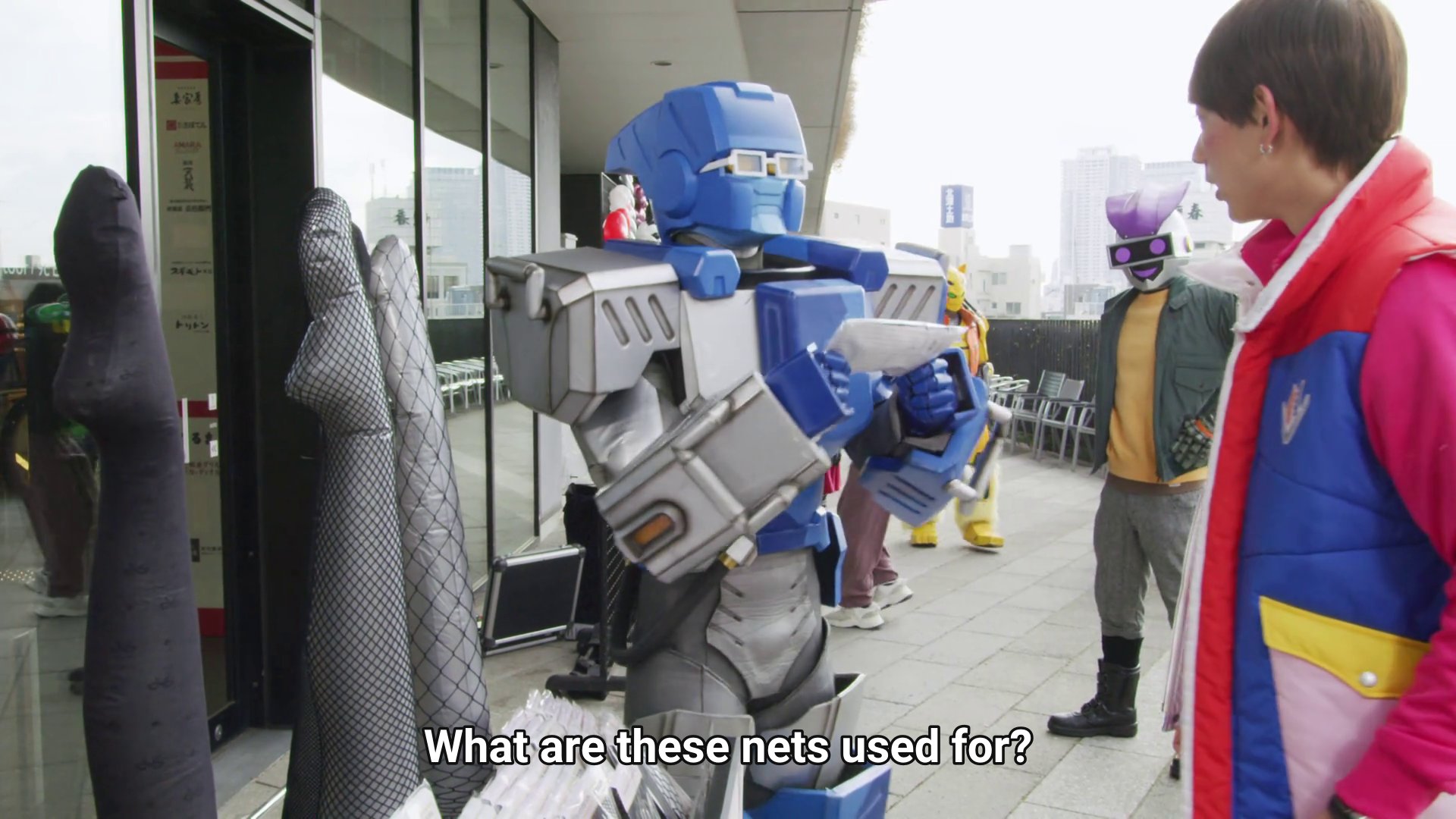 Broon, a blue and grey robot, very square and wearing glasses, beside a display of stockings and talking to Kaito: What are these nets used for?