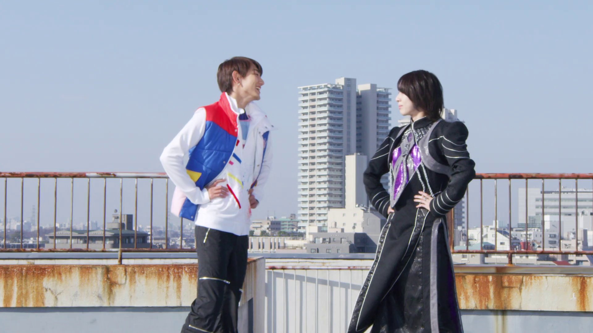 Kaito and Stacey smiling on a rooftop.